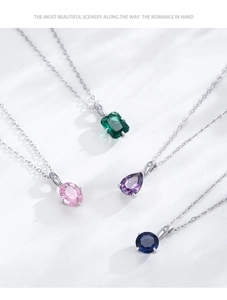 Detail shot of 925 silver necklaces with emerald, pink, purple and blue gemstone pendants