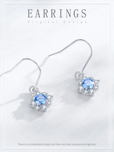 Macro detail of S925 silver flower earrings with blue zircon and delicate engraving