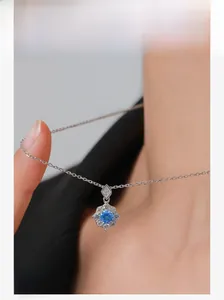 Macro shot of S925 silver necklace with blue zircon flower pendant on model