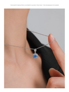 Detailed close-up of S925 silver necklace with blue zircon snowflake pendant worn by model
