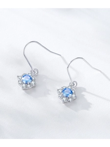 Macro detail of S925 silver flower earrings with blue zircon and pavé crystals
