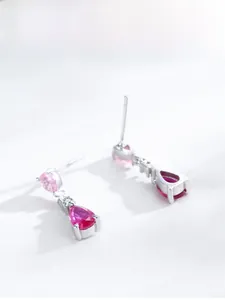 Macro detail of S925 silver earrings with pink and rose red teardrop crystal drops