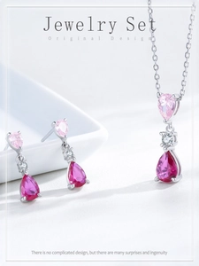 Macro-opname van zilveren sieradenset met peer-geslepen roze zirkonia op display