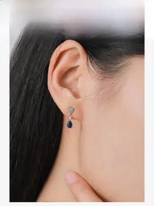 Model wearing S925 silver earrings with light blue and dark blue teardrop zircons