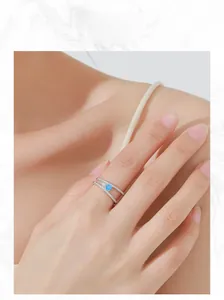 Detail of S925 sterling silver double-layer ring with sea blue zircon on model finger