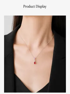 Detail van S925 zilveren ketting met roze en rode druppelvormige zirkoon op een vrouwelijk model