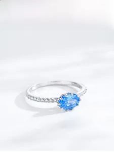 Macro shot of S925 silver ring featuring oval blue zircon and side diamond accents