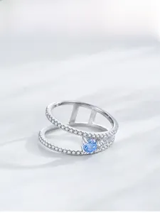 Macro shot of double-layered S925 silver ring with blue zircon and pavé setting