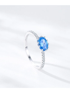 Detailed view of an oval blue gemstone ring with zircon-encrusted silver crown setting