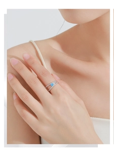 Close-up of elegant double-layer S925 silver ring featuring a round blue zircon gemstone