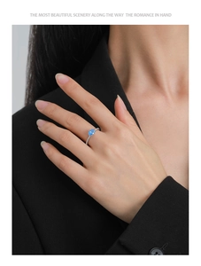 Detail of S925 silver ring with oval sky blue zircon stone worn on model finger
