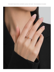 Close-up of a S925 silver ring with oval champagne zircon and pavé diamonds worn by a model