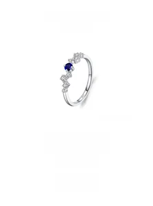 Macro view of S925 sterling silver wave ring with blue sapphire and white diamonds