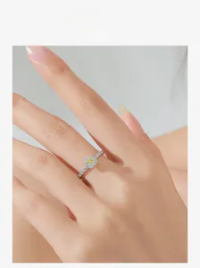 Detail shot of a silver ring featuring a yellow cushion-cut zircon with a diamond halo