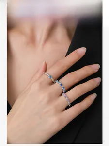 Close-up of a hand wearing three colorful S925 silver rings with heart-shaped cubic zirconia