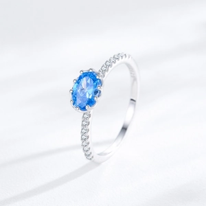 Minimalist S925 sterling silver ring featuring oval blue zircon and pavé accent stones
