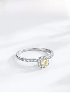 Macro shot of silver ring featuring a yellow square gemstone with micro-pave zircon details
