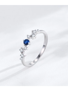Detail of S925 silver wave ring featuring a central blue sapphire and sparkling side stones