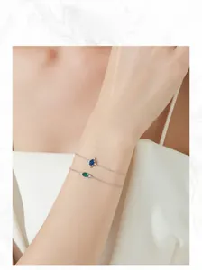 Dettaglio di bracciali in argento S925 con zirconi ovali color smeraldo e zaffiro