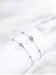 Detail of silver S925 bracelet featuring zircon double butterfly charms on a white prop