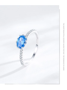 Close-up of S925 sterling silver ring with oval blue zircon and micro-pave crystals