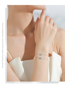 Detail of S925 silver bracelets with round and square sky blue stones on model's wrist
