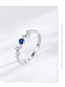 Detailed shot of S925 silver ring featuring blue center stone and wave zircon accents