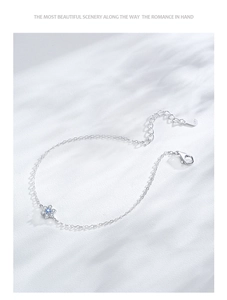 Close-up of S925 sterling silver floral bracelet with blue gemstone and zircon petals