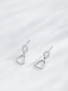 Vue macro de boucles d'oreilles en argent S925 avec zircons blancs et design géométrique