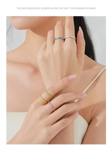 Close-up of five colorful enamel S925 silver rings with tiny zircon stones on model's hand