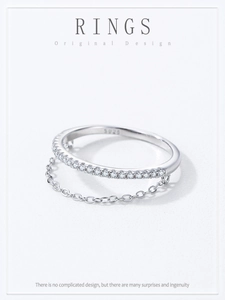 Macro shot of S925 sterling silver ring with delicate chain and sparkling zircon row