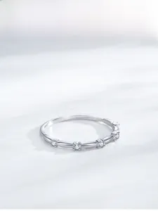 Détail macro d'une bague en argent S925 avec quatre zircons sertis griffes sur l'anneau