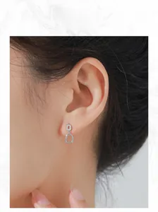 Gros plan de boucles d'oreilles géométriques creuses en argent S925 sur un mannequin