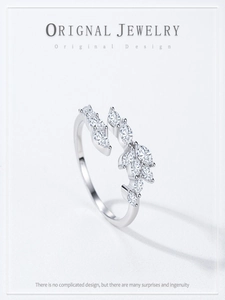Detailed macro shot of an adjustable silver leaf ring with marquise-cut white crystals
