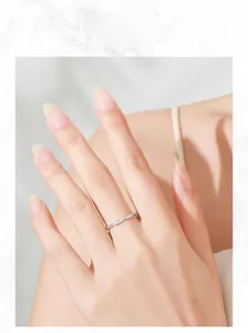 Detail of minimalist silver intertwined ring with micro-pave diamonds on hand