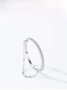 Macro shot of S925 sterling silver ring with delicate chain and paved diamonds