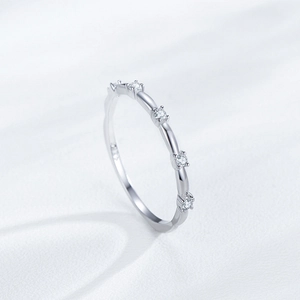 Bague élégante en argent S925 avec cinq zircons étincelants sur un fond de soie blanche