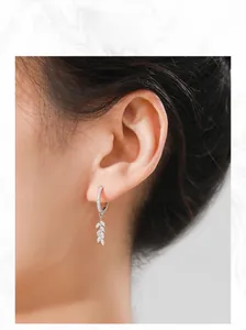 Detail view of S925 sterling silver leaf earrings with marquise zirconia on model