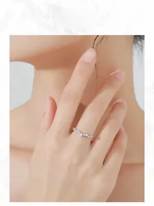 Detail of S925 sterling silver V-shape wave ring with sparkling zircon cluster on finger