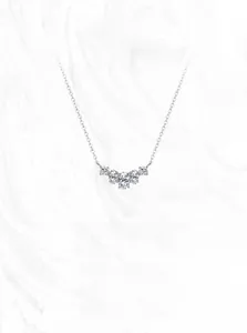 Detailed view of S925 silver necklace with five sparkling curved zircons on marble