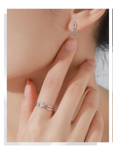 Detail of silver double-layered openwork ring and matching pavé hoop earrings on model