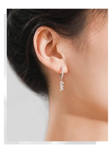 Detail of S925 sterling silver leaf earrings with marquise-cut zircon stones on a model