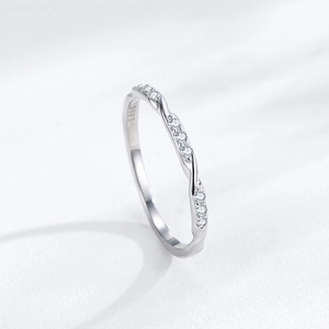 Minimalist S925 sterling silver twisted ring with sparkling paved stones on white background