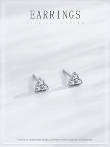 Macro detail of silver geometric triangle stud earrings with three clear cubic zirconia stones