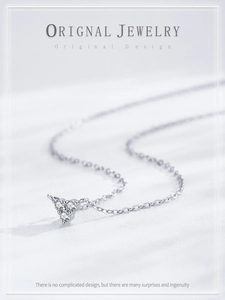 Macro shot of S925 sterling silver triangle necklace with three round sparkling zircons