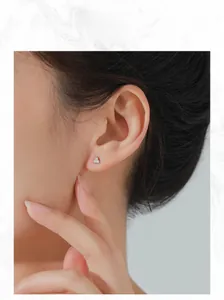 Close-up of minimalist S925 sterling silver triangle stud earrings with sparkling stones