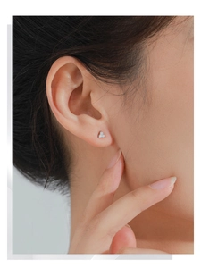 Close-up of minimalist S925 sterling silver triangle stud earrings with sparkling zircons