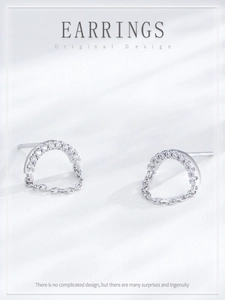 Macro shot of S925 silver U-shape earrings with zircon pavé and delicate hanging chain