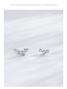 Macro shot of minimalist S925 sterling silver triangle earrings with triple diamond inlay