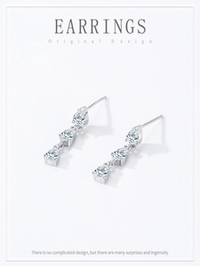 Detail of silver drop earrings with three pear-cut cubic zirconia stones on white background
